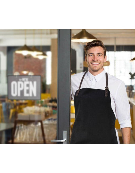 K0015AB | Grembiule da Lavoro in Canvas/ Vera Pelle pieno fiore, volanata. Colore Nero/Testa Moro. Accessori Nickel Anticato. Dimensioni: cm 70 x 90 x 0,5. Confezione: Polybag-1